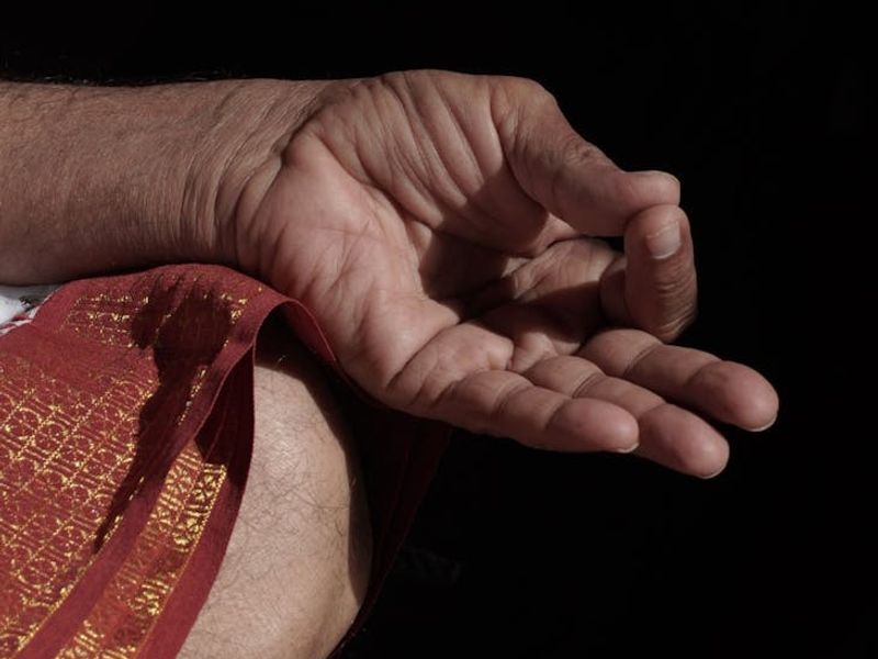 Close-up of a person's hands in a complex yoga mudra.